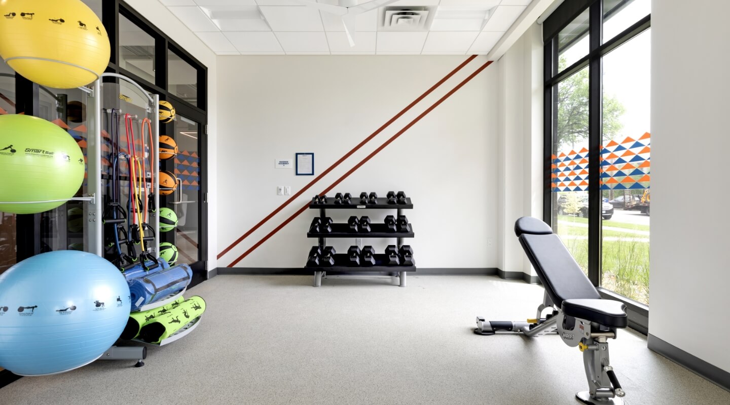 Fitness room with exercise equipment and colorful wall accents.